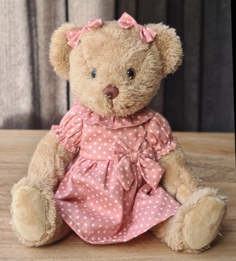 Plyšový medvěd v růžových šatech s puntíky