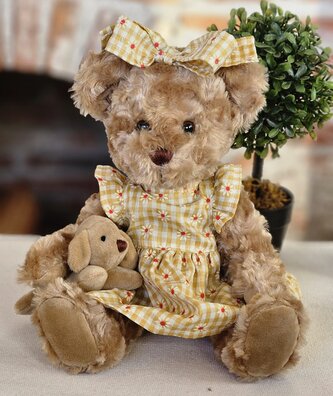 Plyšový medvěd ve žlutých šatičkách s pejskem