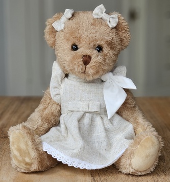 Plyšový medvěd v béžových šatech s šátkem